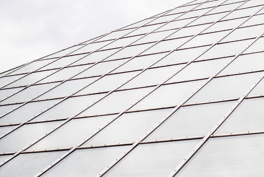 This is a glass wall with a metal frame supporting a modern structure. Background