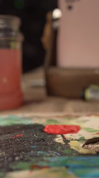 artist with paintbrush taker red paint for artwork, close-up. artist's professional paints. concept of creativity