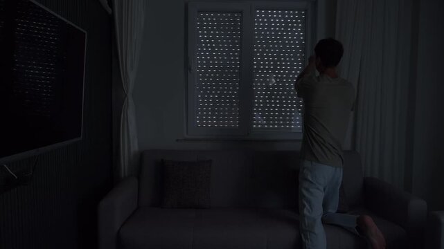 Closing blinds in dark apartment, emotional isolation and mental health concept with cinematic shadows and lonely home atmosphere