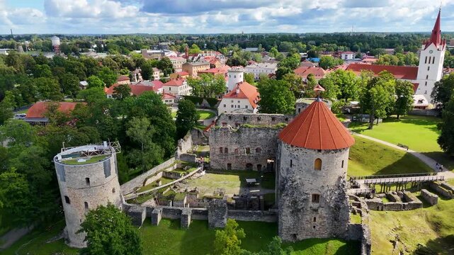 Aerial drone view of Cesis town and its medieval castle ruins, Latvia. Scenic urban park with pond and church on a sunny summer day