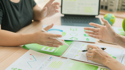The business team is discussing ESG concepts and sustainability in the office. Professional colleagues are planning a green business strategy using ESG investment criteria. (Close-up view) © ArLawKa