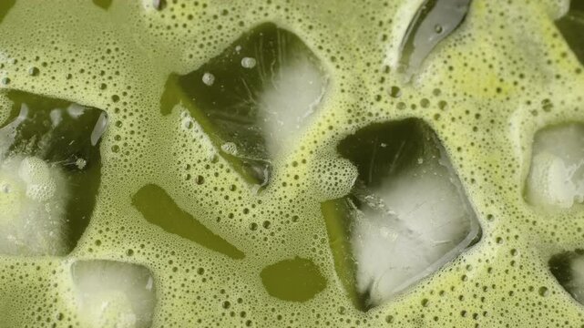 Iced matcha macro texture. Matcha tea with ice close up, rotation