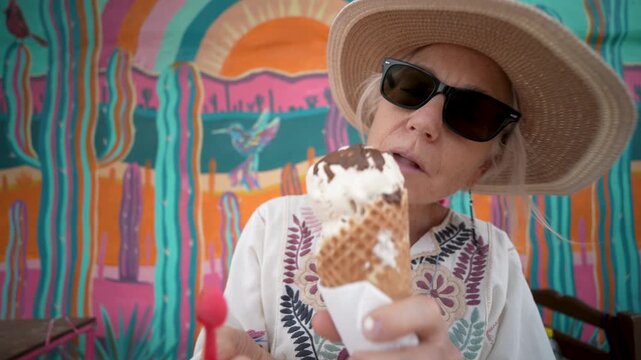 Mature woman tastes ice cream in Mulege as she explores the local sights and food of Baja California Sur in Mexico