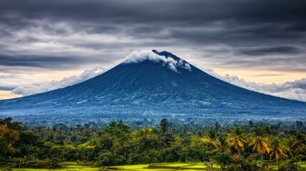Fototapeta premium Majestic Volcano Surrounded by Lush Green Landscape Under Dramatic Cloudy Sky