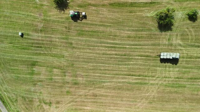 Aerial View of Tractor Working on Hay Field in Rural Countryside