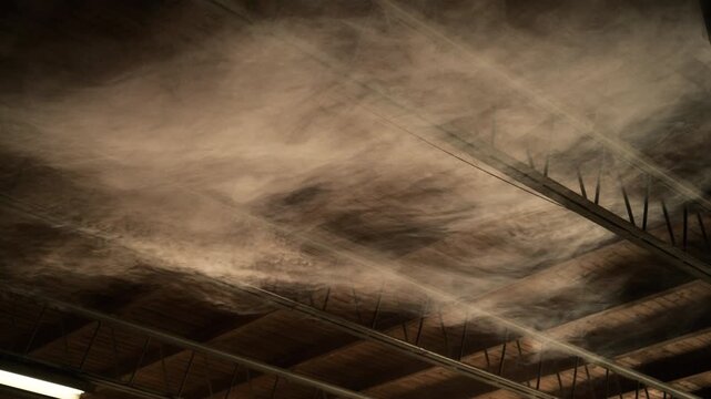 Smoke drifting beneath industrial ceiling with fluorescent light, atmospheric indoor scene with dramatic texture, 4K