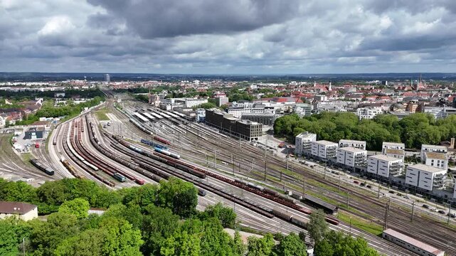 Wide aerial sweep across Augsburg station district at midday