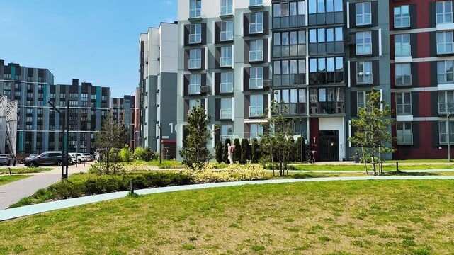 Professional tick and pest control treatment in a modern residential complex. Exterminator in protective suit spraying lawns and plants. Spring pest prevention.