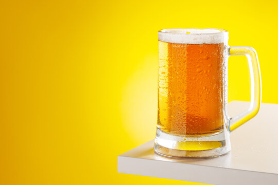 Beer mug with foam yellow background snack setup