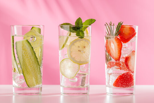 Set of fresh non alcoholic drinks with strawberry cucumber and lemon on pink background