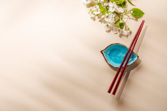 Minimal asian composition with chopsticks and blossom branch