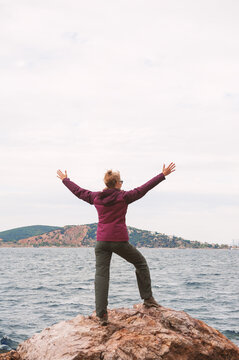 Traveler woman embracing coastal freedom near skyline