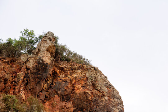 Nature background with wall of rock, sky and green crowns of forest