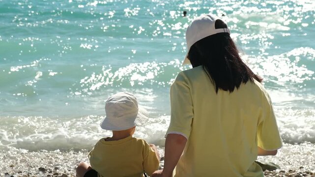 Mother and child sitting by the sea