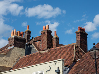 Traditional Brick Chimney Stacks and Terracotta Pots on Historic Rooftops, Titchfield, Hampshire, UK © Solomiia