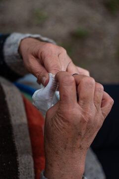 Vertical close up of senior woman embroidering fabric