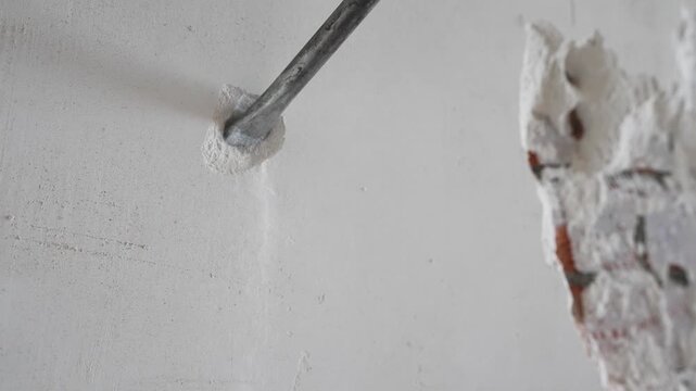 Macro shot of power tool drilling wall during renovation work. Concept of repair and construction activity.
