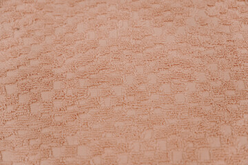 Fototapeta premium Close up texture of soft pink towel material with geometric woven pattern. Bathroom comfort and textile design concept.