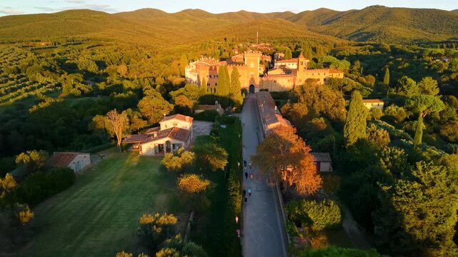 Italy Tuscany Bolgheri aerial 4K drone flight toward borgo sunset golden hills soft light authentic luxury countryside landscape wine region overflight cinematic scenery