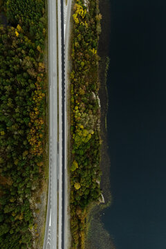 Aerial of Highway Next to Lake in Autumn Sweden