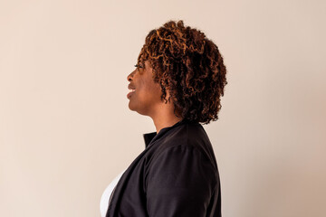 Obraz premium Profile of a person with curly hair wearing a black jacket.