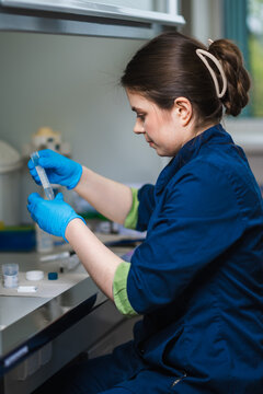 Scientist Conducting Delicate Pipetting Procedures On Diagnostic Samples Within Sterile Laboratory Environment