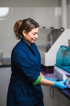 Confident Laboratory Technologist Portrait With Gentle Smile, Navy Uniform And Gloves, Approachable