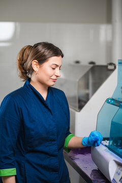 Female Technician Operating Analyzer While Pipetting Sample, Precise Dispense Into Plate, Protective Gloves