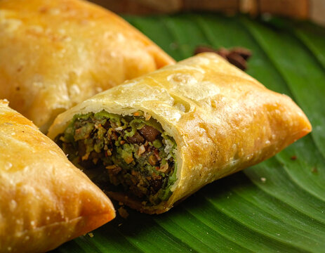 Crispy fried samosa with savory filling on leaf