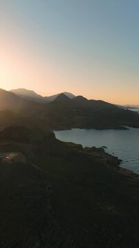 Drone view of sunrise over the Cretan Mountains on the Mediterranean sea coastline, vertical video
