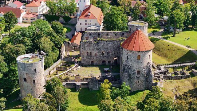 Aerial drone view of Cesis town and its medieval castle ruins, Latvia. Scenic urban park with pond and church on a sunny summer day