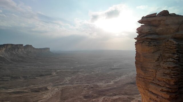 Dramatic cliffs of Tuwaiq mountain range at sunset creating breathtaking view over vast desert landscape near Riyadh, Saudi Arabia, showcasing beauty and tranquility of nature