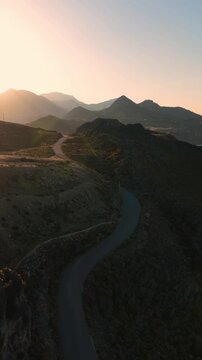 Scenic road on the Mediterranean coastline through the Cretan mountains, aerial video at sunrise
