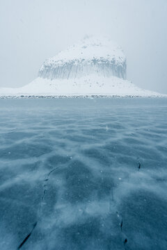 Edinburgh Hill basalt columns in Antarctica in snowy conditions with sea ice forming in the foreground