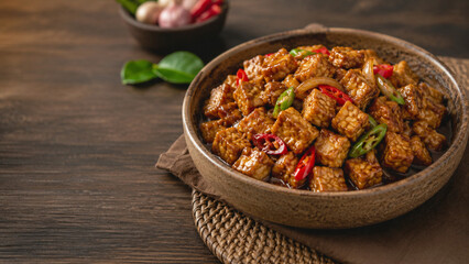 Fototapeta premium Sweet Soy Tempeh Stir Fry with Chili Peppers in Rustic Bowl