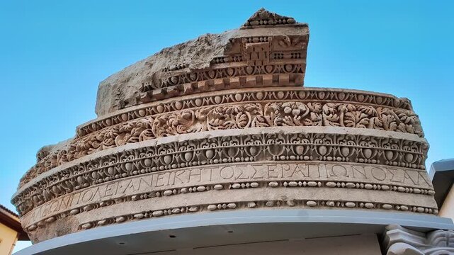Antique roman carved stone architrave with greek inscription and floral relief on display in antalya.