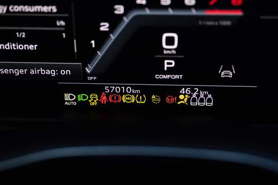 Many different car dashboard lights with warning lamps illuminated. Light symbol that pops up on dashboard when something goes wrong with the engine. Close up shot of hybrid car instrument panel