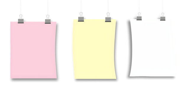 A collection of three curved colorful paper sheets hanging from metal binder clips with strings.