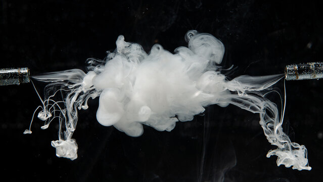 White smoke curls against a dark backdrop, forming unique shapes and patterns that slowly rise upwards