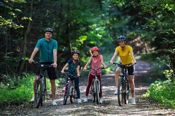 Obraz premium Active family enjoying biking adventure in scenic landscape.