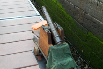 Obraz premium Vintage cannon on the dock. Four inch blank firing cannon used in reenactments, waiting to be loaded onto a ship.