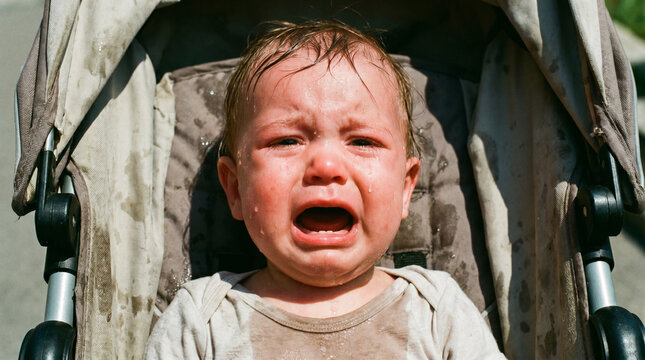 Crying exhausted baby sweating heavily in a stroller under direct hot sun without a hat, suffering from extreme summer heat and risk of sunstroke