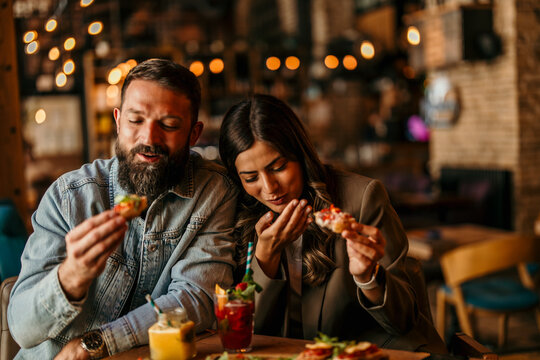 Couple enjoying appetizers and cocktails at a restaurant
