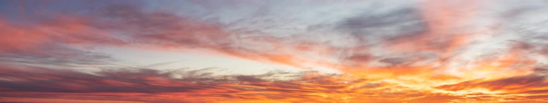 Panoramic sunset sky with orange clouds and dramatic twilight horizon background