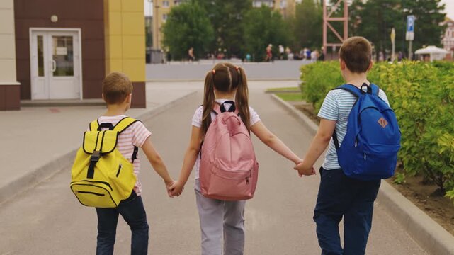 Shiny school bags, Early morning walk, Fun with friends before school, School-aged children in the city, Preparing for lessons, Cozy and safe walk, Holding on to friendship, Smiling towards learning
