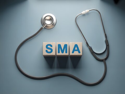 Medical stethoscope resting on wooden blocks spelling out SMA on a blue background representing healthcare and medicine