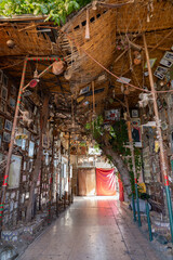 Fototapeta premium Sheltered medina alleyway filled with handicrafts, paintings, and decor in Morocco