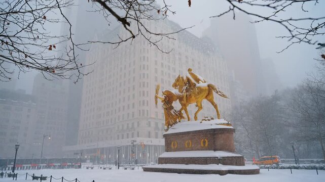 The William Tecumseh Sherman Monument is heavily sprinkled with snow. Blizzard in New York City, USA.