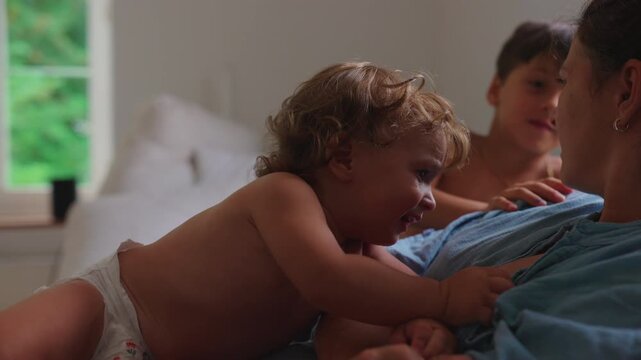 Frustrated toddler reaching toward mother while seeking breastfeeding comfort during emotional family moment, attachment and authentic parenting challenges