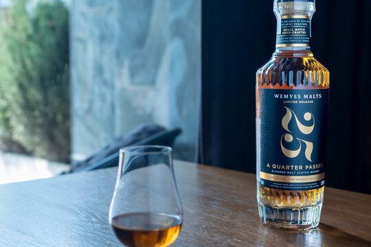 Wemyss Malts 25 years old blended malt Scotch whisky bottle with a tasting glass on a wooden table. Premium luxury alcohol product photography. Ukraine, Zhytomyr, May 21, 2026